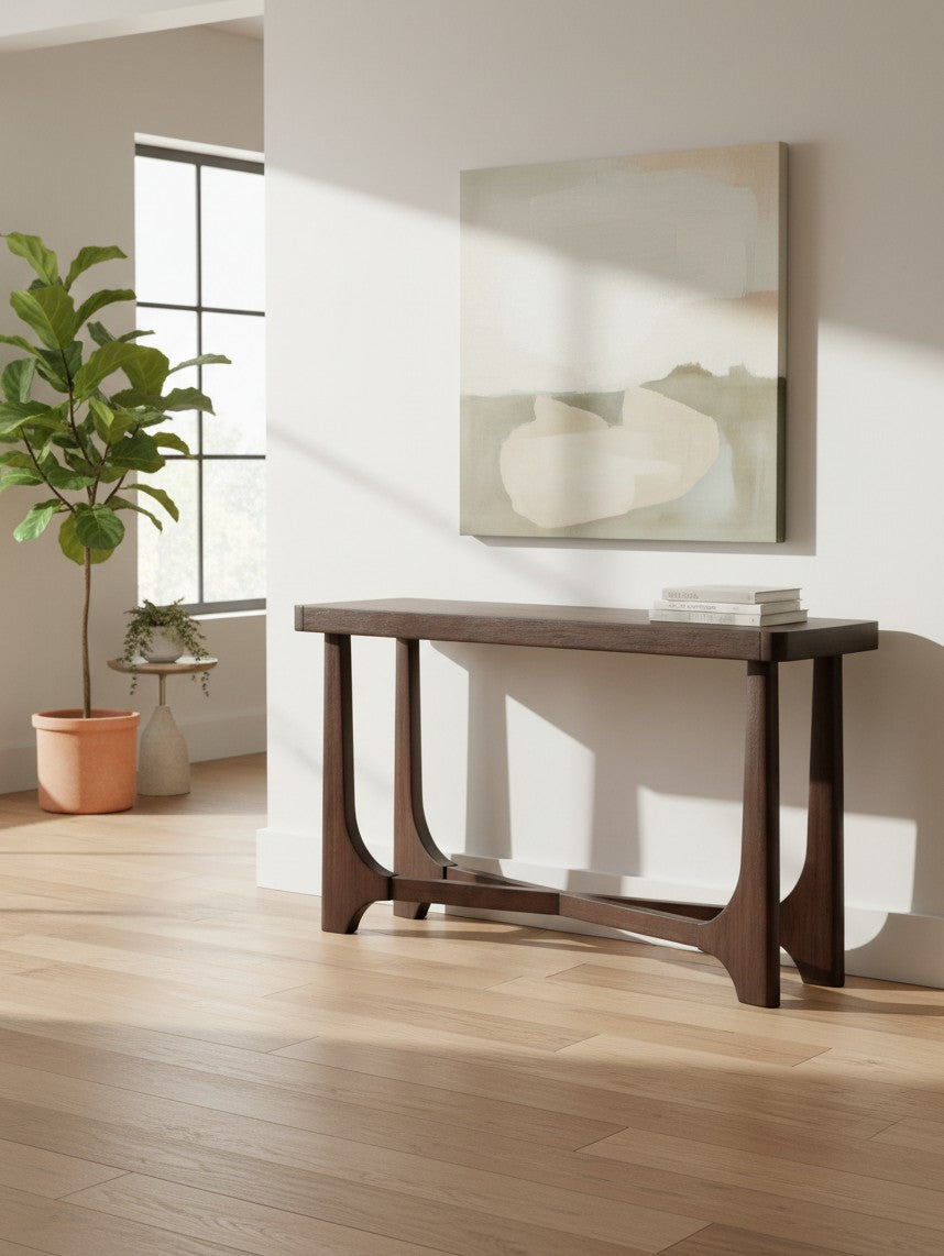 Table console Louma par TOCO Meubles en bois foncé avec pieds arqués dans un salon lumineux et moderne