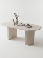 Table de cuisine ovale TOCO Meubles en bois clair avec pieds cannelés et décoration minimaliste sur fond blanc