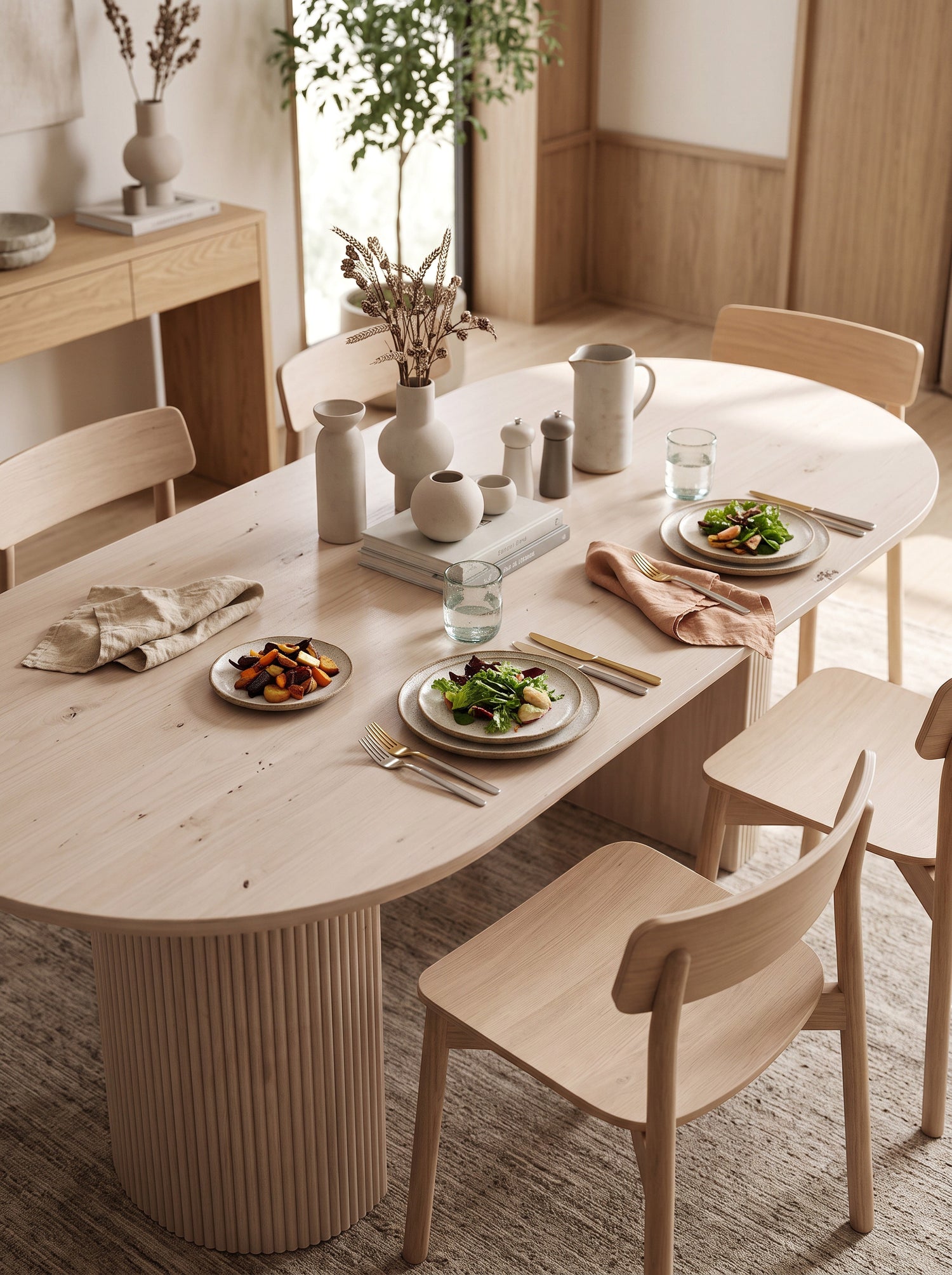 Table de cuisine ovale en bois clair TOCO Meubles avec pieds cannelés dans une salle à manger minimaliste
