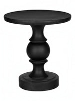 Table d'appoint Apolo noire en oxyde de magnésium, avec un design sculpté et une base ronde.