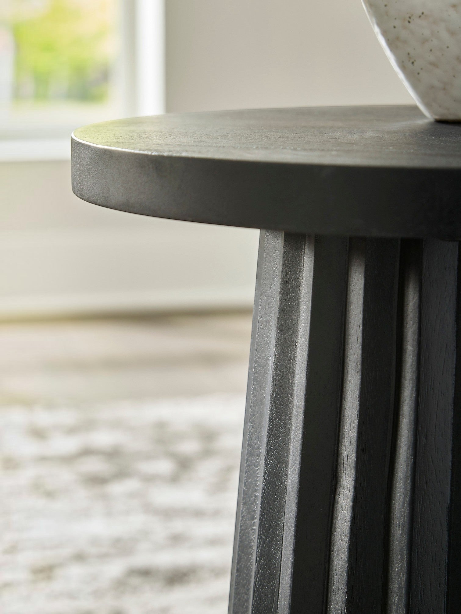 Table d'appoint ronde noire en bois massif TOCO Meubles avec base cannelée sculpturale.