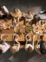 Famille attablée autour d'une grande table à manger extérieure extensible en bois TOCO Meubles pour un repas festif