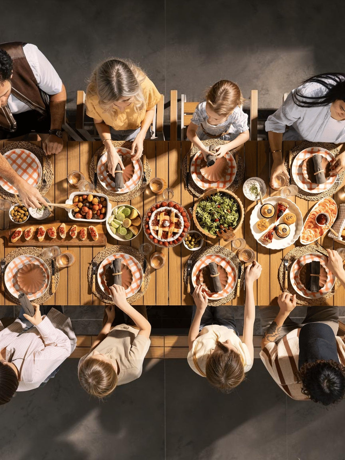 Famille attablée autour d'une grande table à manger extérieure extensible en bois TOCO Meubles pour un repas festif