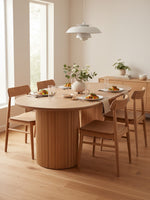 Table de salle à manger ovale Luno par TOCO Meubles en bois clair avec un pied central cannelé dans une salle à manger