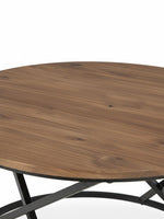Gros plan sur le plateau rond en bois brun de la table basse TOCO Meubles avec structure en métal noir