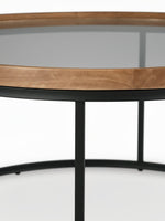 Table de salon ronde Nora de TOCO Meubles avec plateau en bois naturel et verre fumé sur pieds en métal noir