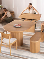 TOCO Meubles Table de salle à manger ronde en chêne scandinave, extensible, avec pieds cannelés et 2 femmes démontrant son mécanisme.