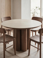 Table ronde TOCO Meubles Haton avec plateau en pierre frittée effet travertin et base centrale en bois de noyer