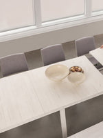 Table de salle à manger extensible en bois blanc TOCO Meubles, une femme ajoute une rallonge. Style moderne.