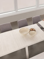 Table de salle à manger extensible en bois blanc TOCO Meubles, une femme ajoute une rallonge. Style moderne.
