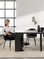 Femme assise à une table de salle à manger extensible TOCO Meubles en bois hickory fumé dans un intérieur moderne
