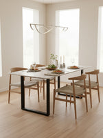 Table de salle à manger Fiora TOCO Meubles avec plateau en marbre blanc et pieds en métal noir dans une salle à manger