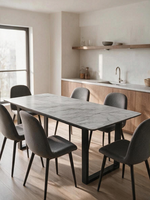 Table de salle à manger extensible Avino par TOCO Meubles avec dessus effet marbre et pieds en métal noir mat.
