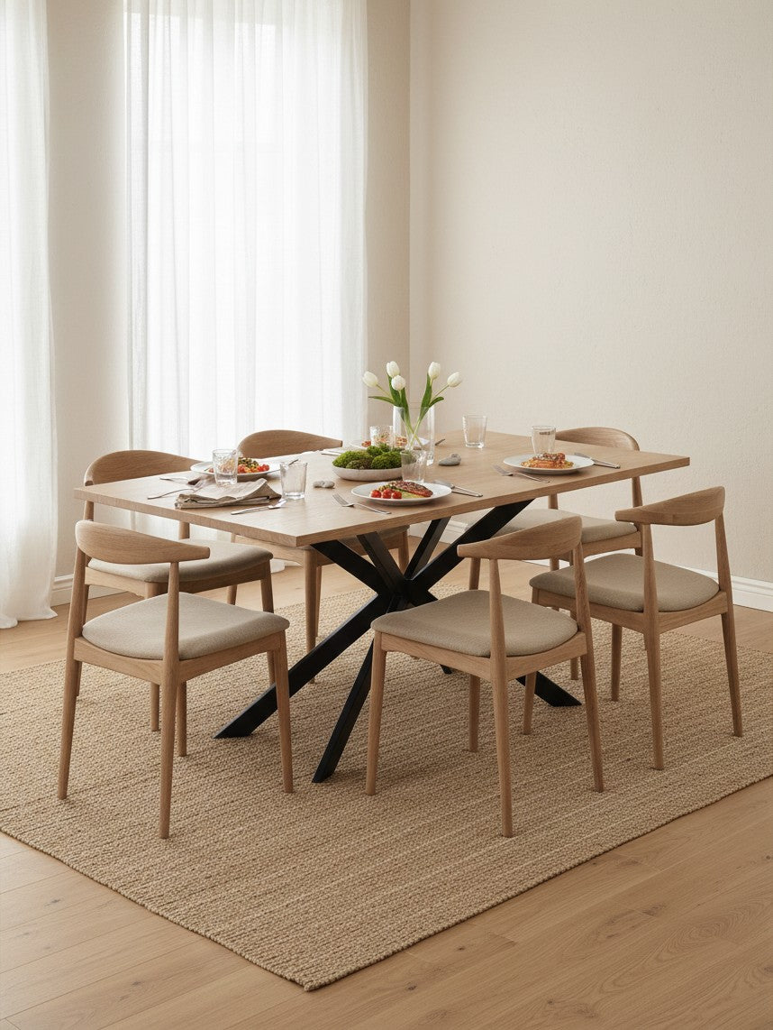 Table de salle à manger Olina par TOCO Meubles avec plateau en bois clair et pieds en métal noir, entourée de chaises