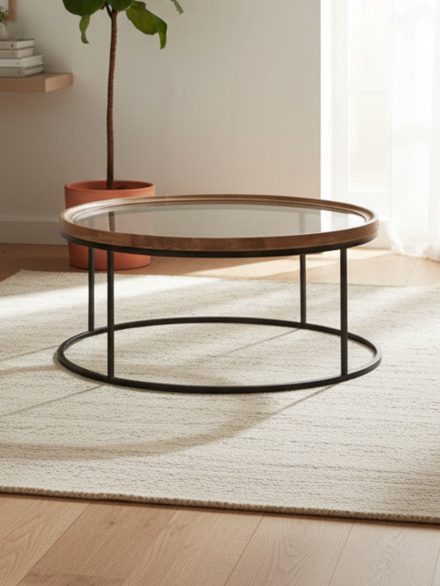 Table de salon ronde Nora de TOCO Meubles avec plateau en verre et cadre en bois naturel sur pieds en métal noir