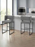 Deux tabourets de bar gris Myko de TOCO Meubles avec assise rembourrée et structure en métal noir dans une cuisine