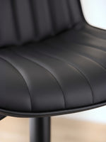 Gros plan sur le revêtement en PU noir du tabouret de bar Ali par TOCO Meubles avec ses coutures verticales élégantes.