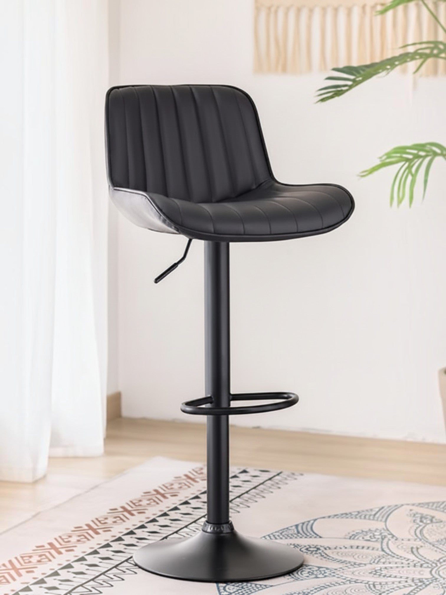 Tabouret de bar TOCO Meubles Ali en PU noir avec coutures verticales, réglable et pivotant sur pied en métal noir.