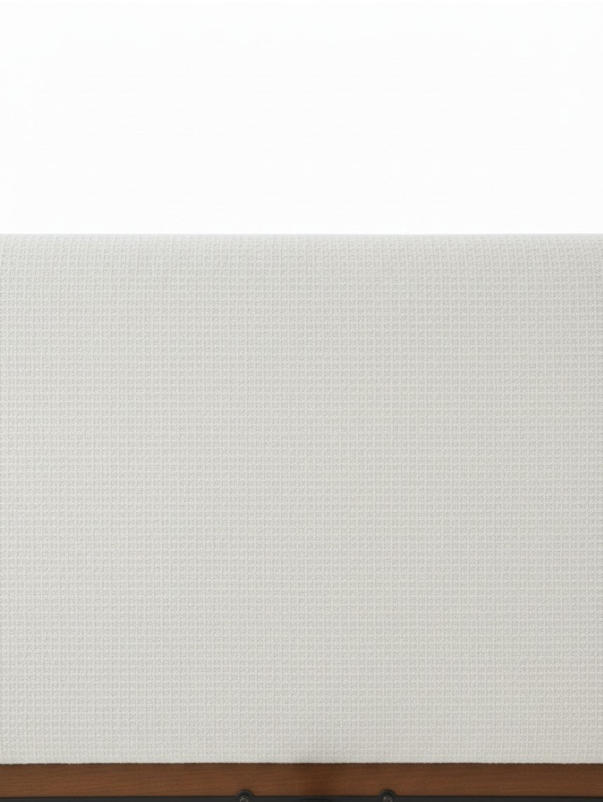 Gros plan sur la tête de lit rembourrée en tissu chenille gris pâle du lit TOCO Meubles Henri avec cadre en bois