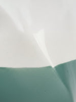 Gros plan sur la texture bicolore blanc et vert sauge du vase en céramique Tethys de TOCO Meubles