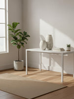 Vase en céramique blanche nacrée à rayures TOCO Meubles posé sur une table blanche dans un intérieur lumineux