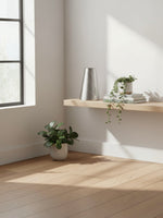 Vase en métal argenté texturé TOCO Meubles posé sur une étagère en bois dans un intérieur moderne et lumineux