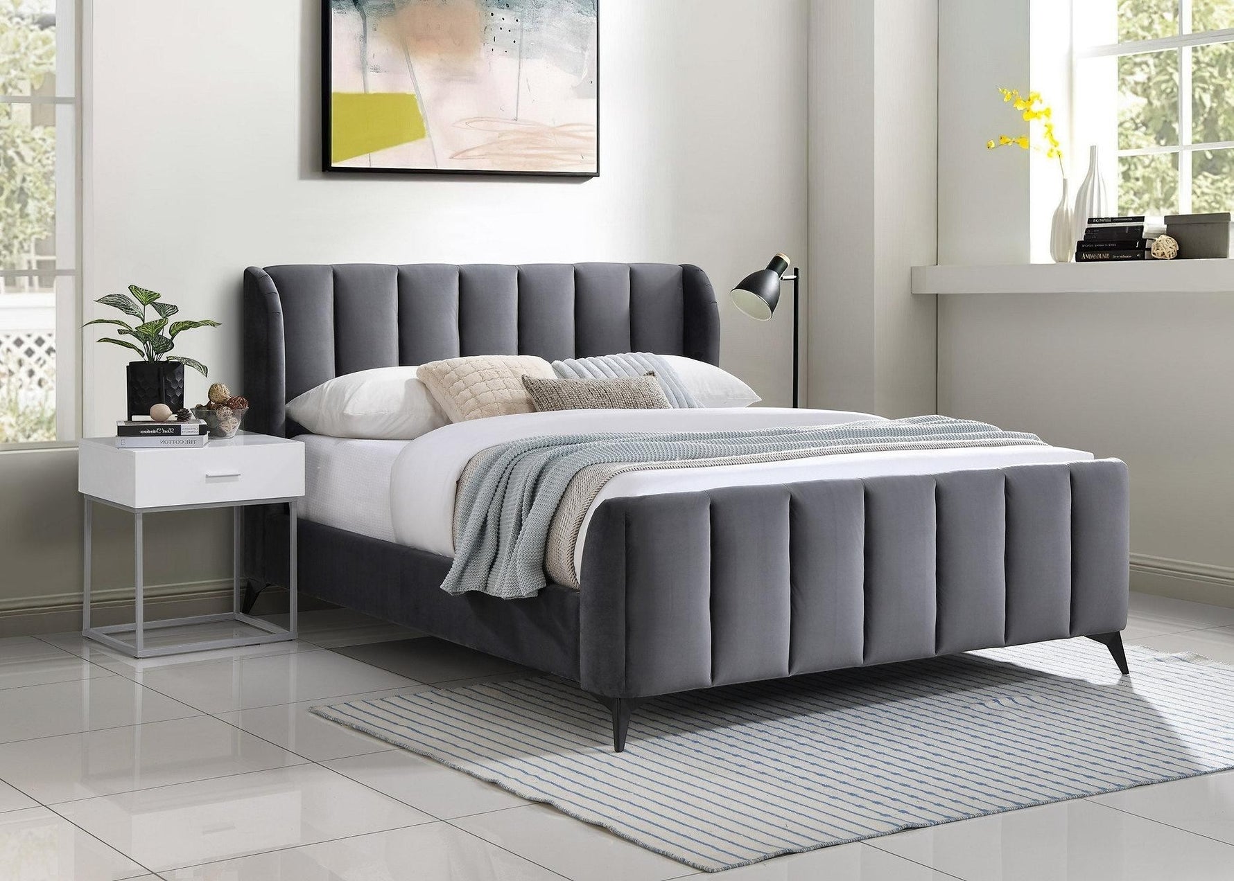 TOCO Meubles Lit Juliette grand lit en velours gris avec tête de lit capitonnée et pieds en métal noir.