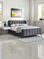 TOCO Meubles Lit Juliette grand lit en velours gris avec tête de lit capitonnée et pieds en métal noir.