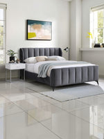 TOCO Meubles Lit Juliette grand lit en velours gris avec tête de lit capitonnée et pieds en métal noir.