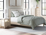Lit à panneaux TOCO Meubles Margot en bois clair avec tête de lit rembourrée texturée, style boho minimaliste.