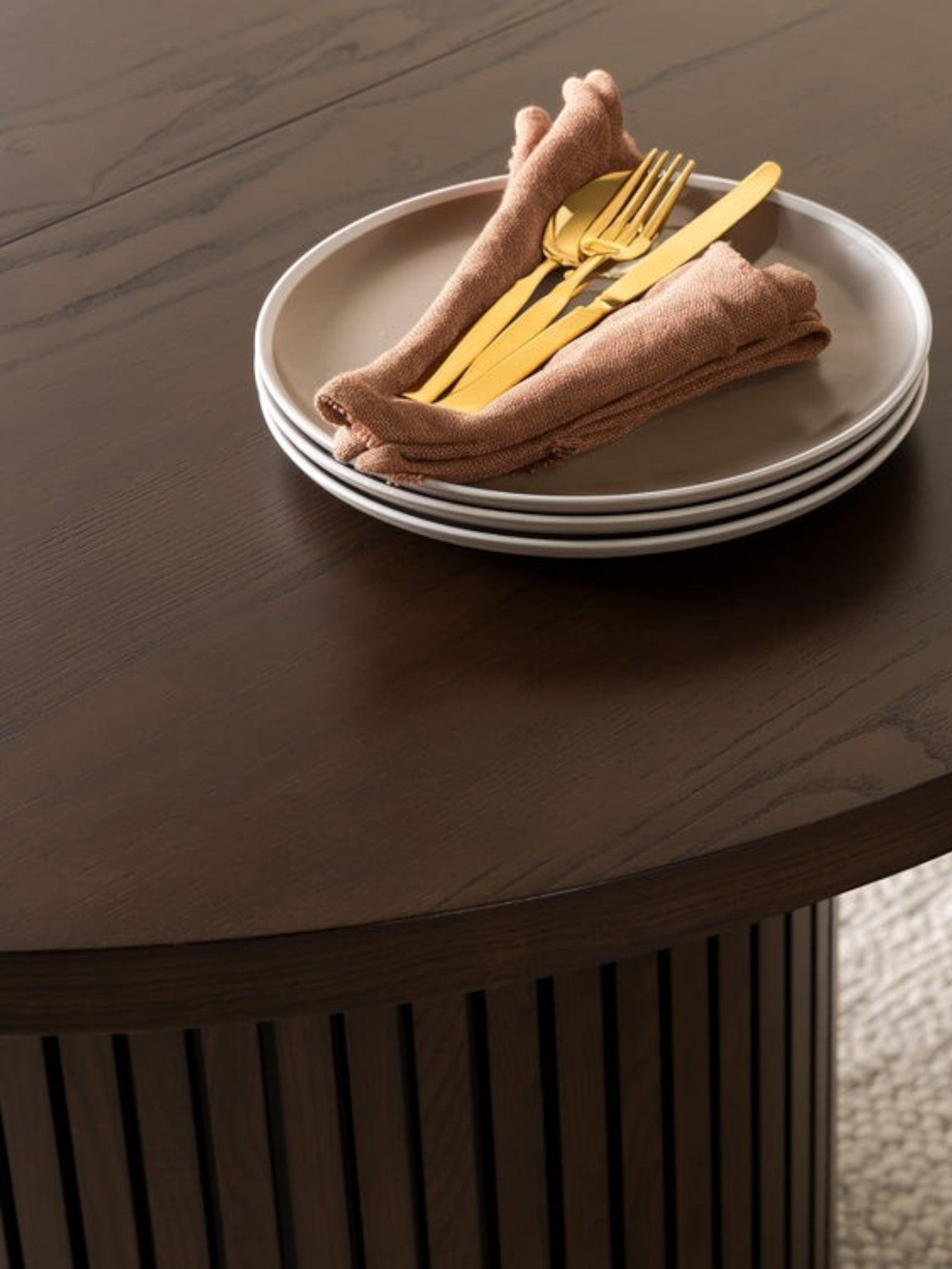 Table de salle à manger ronde TOCO Meubles en bois de noyer foncé, avec base cannelée et service de table doré.