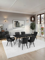 Table de salle à manger Remy noire style industriel en marbre avec 6 chaises noires capitonnées par TOCO Meubles.